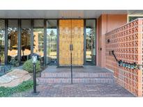 Building entrance with ornate doors and brick steps at 4570 E Yale Ave # 702, Denver, CO 80222