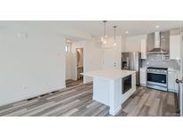 Modern kitchen with stainless steel appliances and island at 6927 Kendrick Ln, Arvada, CO 80007