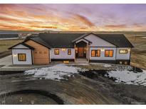 Stunning aerial view of a two-story home with a large yard at sunset at 44035 Pony Express Ct, Elizabeth, CO 80107