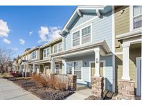 Row of charming townhouses with light blue and green exteriors at 15612 E 96Th Way # 6D, Commerce City, CO 80022