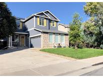 Charming two-story home with gray siding, yellow shutters, and a landscaped front yard at 1612 E 164Th Pl, Thornton, CO 80602