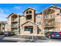 Tan three-story building with balconies and ample parking at 10805 Twenty Mile Rd # 307, Parker, CO 80134