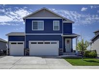 Two-story blue house with white two-car garage and landscaping at 45780 Silverdrop Ave, Bennett, CO 80102