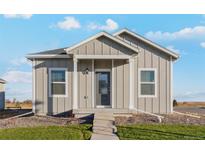A charming one-story home with light gray siding and a welcoming front porch at 3012 Oxley St, Strasburg, CO 80136