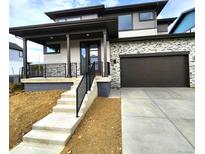 Modern home's exterior with stone, wood, and large windows at 5620 Cottontail Dr, Longmont, CO 80503