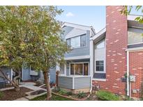 Front view of a townhome with gray siding and brick accents at 11722 E Cedar Ave, Aurora, CO 80012