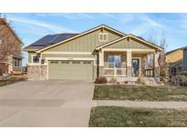 Charming two-story home with solar panels, a covered porch, and a two-car garage at 24387 E 5Th Pl, Aurora, CO 80018