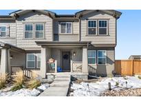 Two-story townhome with gray siding, front porch, and landscaping at 28314 E 6Th Pl, Watkins, CO 80137