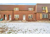 Brick townhouse exterior with snow-covered lawn and walkway at 5667 S Lowell Blvd, Littleton, CO 80123