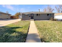 Charming ranch home with a landscaped lawn and walkway at 1059 S Saulsbury St, Lakewood, CO 80226
