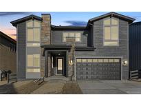 Two-story home with gray siding, stone accents, and a two-car garage at 6666 Bridle Creek Pt, Castle Pines, CO 80108