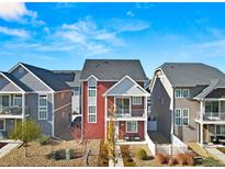 Red two-story townhome with balcony and small fenced yard at 5367 N Argonne St, Denver, CO 80249