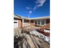Brick ranch home with a covered porch and landscaping at 3306 S Uinta Ct, Denver, CO 80231
