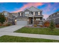 Two-story home with gray siding, attached garage, and landscaped lawn at 23890 E Minnow Dr, Aurora, CO 80016