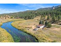 Aerial view of house near river and mountain at 2677 S Platte River Rd, Sedalia, CO 80135