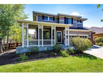 Two-story house with front porch, attached garage, and landscaped yard at 446 N Coolidge Way, Aurora, CO 80018