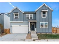 Two-story craftsman style home with gray siding, white trim, and a two-car garage at 9359 Russell Cir, Arvada, CO 80007