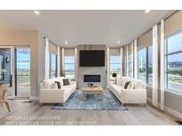 Bright living room with two sofas, a coffee table, and a fireplace at 1765 Peak Loop, Broomfield, CO 80023