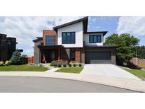 Modern two-story home with wood and white siding, landscaped yard, and attached garage at 4224 E Dickenson Pl, Denver, CO 80222