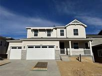 Two-story house with beige siding, white garage door, and a covered porch at 5525 Riverbend Ave, Firestone, CO 80504