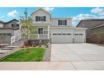 Two-story house with gray siding, white trim, and a two-car garage at 3332 N Highlands Creek Pkwy, Aurora, CO 80019