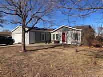 Ranch style home with gray siding, attached garage, and a spacious yard at 1103 Stage Dr, Fort Lupton, CO 80621