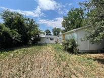 Large backyard with overgrown grass and two buildings at 1325 N Wabash St, Denver, CO 80220