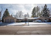 Charming two-story home with a snow-covered front yard and attached garage at 6300 W Plymouth Dr, Littleton, CO 80128