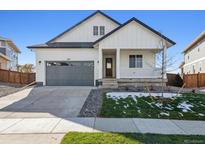 Craftsman style home with gray garage door and front porch at 3212 Boral Owl Dr, Brighton, CO 80601