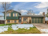 Green two story home with attached garage and landscaping at 8822 W Stanford Ave, Littleton, CO 80123