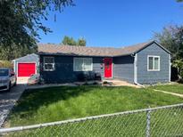 Charming single-story home with gray siding, red door, attached garage, and fenced front yard at 1275 S Wolff St, Denver, CO 80219