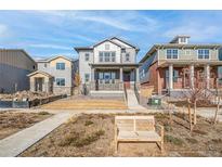 Two-story home with gray siding, red door and attached two-car garage at 21284 E 63Rd Dr, Aurora, CO 80019