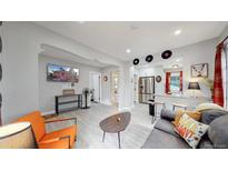 Living room with a modern aesthetic, featuring a comfy couch and large TV at 730 E Alameda Ave, Denver, CO 80209