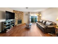 Living room features hardwood floors and a stone fireplace at 10150 E Virginia Ave # 2-205, Denver, CO 80247