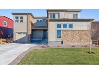 Two-story house with stone and light-brown siding, two-car garage, and landscaping at 1742 Morgan Dr, Erie, CO 80516