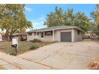 Ranch style home with attached garage and mature landscaping at 8467 W 62 Pl, Arvada, CO 80004