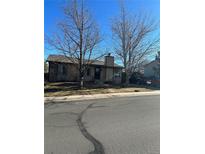 Tan house with a well-maintained lawn and trees at 3942 S Helena St, Aurora, CO 80013