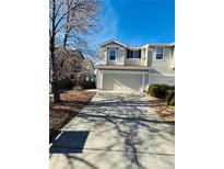 Tan two-story house with attached garage and driveway at 5307 S Picadilly Way, Aurora, CO 80015