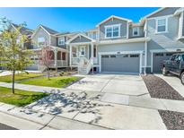 Two-story townhome with gray siding, attached garage, and landscaped front yard at 17785 Fox St, Broomfield, CO 80023