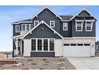 Two-story home with gray and white siding, white garage door, and landscaping at 5566 Hickory Oaks Trl, Castle Rock, CO 80104