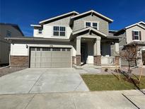 Two-story house with gray siding, a large front yard, and a two-car garage at 4823 Astor Pl, Brighton, CO 80601