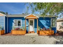 Charming blue house with white door, wood planters, and gravel driveway at 1245 Tamarac St, Denver, CO 80220