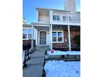Brick townhouse exterior with balcony, steps, and snowy landscaping at 17136 E Tennessee Dr, Aurora, CO 80017