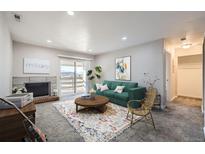 Bright living room with fireplace, balcony access, and mountain views at 519 Wright St # 304, Lakewood, CO 80228