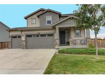 Two-story house with gray siding, stone accents, and a three-car garage at 9437 Richfield St, Commerce City, CO 80022