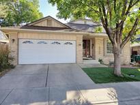 Brick home with a two-car garage and manicured lawn at 710 Kittredge St, Aurora, CO 80011