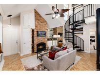 Living room with a stone fireplace, spiral staircase, and comfy seating at 4923 S Carson St # 212, Aurora, CO 80015