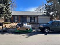 Brick ranch house with a two-car garage and landscaping at 2792 S Macon Cir, Aurora, CO 80014