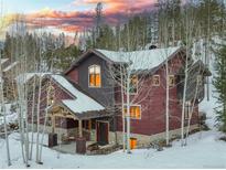 Exterior of a luxury mountain home at sunset with a snowy landscape at 120 Marks Ln, Breckenridge, CO 80424