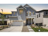 Two-story home with gray siding, white trim, and a covered porch at 11077 Star Fall St, Littleton, CO 80125